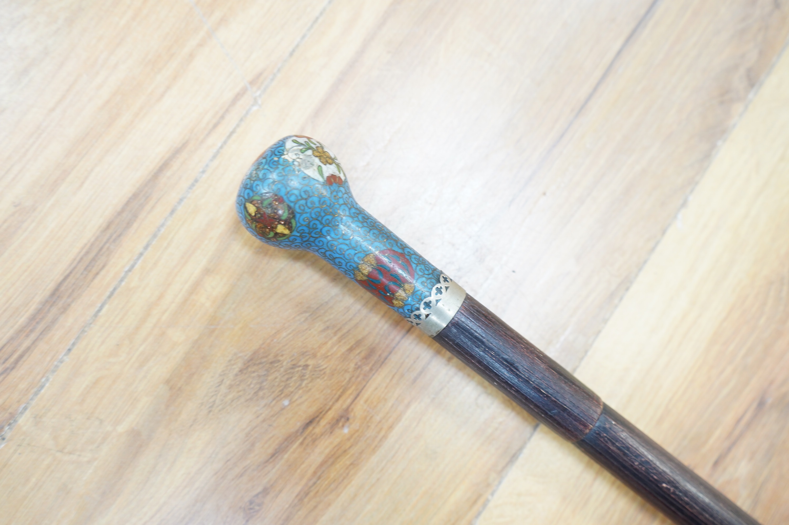 An early 20th century erotica walking stick with cloisonné enamel handle and concealed chain flogger, 86cm long. Condition - good.